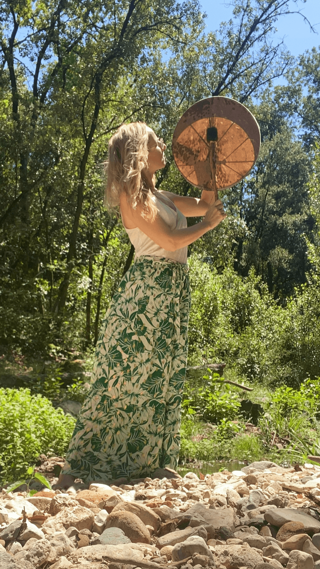 Caroline Durand avec son tambour, au bord de la rivière.